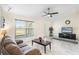 Inviting living room featuring tile flooring, ceiling fan, and a view of the backyard through a large window at 25337 Durango Ct, Punta Gorda, FL 33955