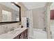 Recently remodeled bathroom with marble counters, dark wood cabinets, and shower-tub combo at 2897 Thaxton Dr # 62, Palm Harbor, FL 34684