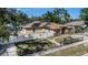 Aerial view showcasing the house with solar panels, fenced yard, and surrounding trees at 3443 16Th Ave S, St Petersburg, FL 33711