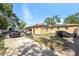 Wide view of the backyard showing the house with solar panels, driveway, and additional storage at 3443 16Th Ave S, St Petersburg, FL 33711