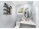Stylish powder room with modern fixtures, round mirror, and elegant gray color scheme at 3443 16Th Ave S, St Petersburg, FL 33711