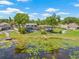 Beautiful aerial view of a lakeside home featuring a screened pool, gazebo, and lush greenery at 3626 Lake Joyce Dr, Land O Lakes, FL 34639