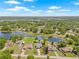 Beautiful aerial view of lakeside homes with green lawns and water access, surrounded by trees at 3626 Lake Joyce Dr, Land O Lakes, FL 34639
