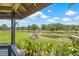 A backyard featuring a lawn, lake, and a neatly stacked wood pile on a sunny day at 3626 Lake Joyce Dr, Land O Lakes, FL 34639