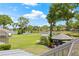 A lush backyard with a view of the lake, featuring a gazebo and well-manicured lawn at 3626 Lake Joyce Dr, Land O Lakes, FL 34639