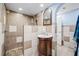 This is a quaint bathroom featuring a tiled shower with a unique tile design and a wooden vanity with an arched mirror at 3626 Lake Joyce Dr, Land O Lakes, FL 34639