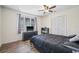 Cozy bedroom with dark furniture, a ceiling fan, and a window with blinds, creating a relaxed and private space at 3626 Lake Joyce Dr, Land O Lakes, FL 34639