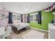 A stylish bedroom with colorful walls, a fan, and natural light streaming through the windows, creating a cheerful atmosphere at 3626 Lake Joyce Dr, Land O Lakes, FL 34639