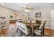 Dining room with seating for six, a ceiling fan, wood floors, and an archway to the kitchen at 3626 Lake Joyce Dr, Land O Lakes, FL 34639