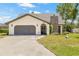 Charming single-story home with a stone chimney and attached two-car garage at 3626 Lake Joyce Dr, Land O Lakes, FL 34639