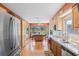 Bright kitchen with wood cabinets, stainless steel appliances, and view to the backyard pool at 3626 Lake Joyce Dr, Land O Lakes, FL 34639