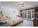 Bedroom featuring a plush bed, ceiling fan, hardwood floors, and access to a screened-in patio at 3626 Lake Joyce Dr, Land O Lakes, FL 34639