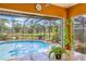 Screened-in pool area boasting a clear swimming pool with lush landscaping and a view of the pond at 3626 Lake Joyce Dr, Land O Lakes, FL 34639