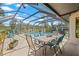 Outdoor dining area adjacent to a screened-in pool offering a relaxing and beautiful space for gatherings at 3626 Lake Joyce Dr, Land O Lakes, FL 34639