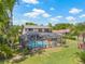 Aerial view of screened pool, patio with furniture, tropical plants, and two story house at 3626 Lake Joyce Dr, Land O Lakes, FL 34639