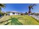 This view of the backyard shows the house, the lush lawn, and tropical landscaping at 4604 Blue Marlin Dr, Bradenton, FL 34208