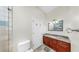 Well-lit bathroom featuring a tiled shower with glass doors, granite countertops, and dark wood cabinets at 4604 Blue Marlin Dr, Bradenton, FL 34208