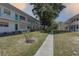 Exterior view of a condo complex featuring a sidewalk and lush landscaping at 5810 21St N St # 10, St Petersburg, FL 33714
