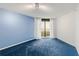Spacious bedroom featuring a sliding glass door to the balcony, blue carpet, and natural light at 5940 Pelican Bay S Plz # 504, Gulfport, FL 33707