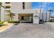 Building entrance with palm trees, manicured landscaping, and an asphalt driveway at 5940 Pelican Bay S Plz # 504, Gulfport, FL 33707