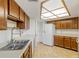 Kitchen featuring wood cabinets, white countertops, double sink, and white refrigerator at 5940 Pelican Bay S Plz # 504, Gulfport, FL 33707