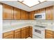 Kitchen featuring light wood cabinets, white countertops, white appliances and a unique ceiling light at 5940 Pelican Bay S Plz # 504, Gulfport, FL 33707