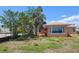 Exterior view of home showcasing the backyard with a large window and mature trees at 600 Boca Ciega Isle Dr, St Pete Beach, FL 33706