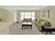 Comfortable living room area with neutral carpet, a large window and green furniture at 6035 19Th Ne St, St Petersburg, FL 33703