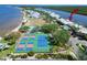 Aerial view of tennis courts, waterfront condos and complex pool with river in the background at 611 Destiny Dr # 205, Ruskin, FL 33570