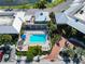 Aerial view of community pool with sun loungers, manicured landscaping, covered area, and parking at 611 Destiny Dr # 205, Ruskin, FL 33570