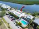 Aerial view of condo building with swimming pool, lounge chairs, a manicured landscape, and ample parking at 611 Destiny Dr # 205, Ruskin, FL 33570