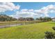 Expansive backyard featuring a beautiful pond with a black metal fence at 6374 Bradford Woods Dr, Zephyrhills, FL 33542
