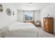 Cozy bedroom with patterned bedding, natural light from the window, and traditional-style wooden dresser at 6374 Bradford Woods Dr, Zephyrhills, FL 33542