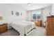 Cozy bedroom with neutral decor, a large window, and a dresser with a decorative lamp at 6374 Bradford Woods Dr, Zephyrhills, FL 33542