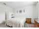 Bedroom featuring neutral decor, bedside table, and doorway leading to an ensuite bathroom at 6374 Bradford Woods Dr, Zephyrhills, FL 33542
