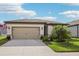 Charming single-story home with a beige exterior, well-manicured lawn, and a two-car garage at 6374 Bradford Woods Dr, Zephyrhills, FL 33542