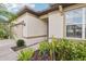 Close-up view of the home's entrance with manicured plants, a large window, and modern door at 6374 Bradford Woods Dr, Zephyrhills, FL 33542