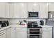 Modern kitchen with stainless steel appliances, double oven and white countertops and cabinets at 6374 Bradford Woods Dr, Zephyrhills, FL 33542