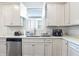 Well-lit kitchen featuring shaker cabinets, stainless steel appliances, and quartz countertops with a tile backsplash at 6374 Bradford Woods Dr, Zephyrhills, FL 33542