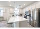Spacious kitchen featuring white cabinets, stainless steel appliances, and a large kitchen island with bar seating at 6374 Bradford Woods Dr, Zephyrhills, FL 33542