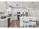 Bright kitchen featuring white cabinets, stainless steel appliances, and a kitchen island with a quartz countertop at 6374 Bradford Woods Dr, Zephyrhills, FL 33542