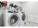 Modern laundry room equipped with front load washer and dryer and ample storage at 6374 Bradford Woods Dr, Zephyrhills, FL 33542
