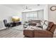 Spacious and bright living room with hardwood floors, plush sectional sofa, and lots of light at 6374 Bradford Woods Dr, Zephyrhills, FL 33542