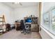 This office includes a desk, large window, and neutral colors at 6374 Bradford Woods Dr, Zephyrhills, FL 33542
