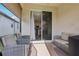 The covered patio offers a lounge area with a view of the kitchen and backyard at 6374 Bradford Woods Dr, Zephyrhills, FL 33542
