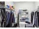 Organized walk-in closet with wire shelving filled with clothing, shoes, and storage containers at 6374 Bradford Woods Dr, Zephyrhills, FL 33542
