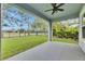 Covered porch with ceiling fan overlooking the lawn, black fence and landscaping at 6611 Current Dr, Apollo Beach, FL 33572