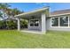 Back porch with ceiling fan overlooking well maintained grassy yard and a backyard pool at 6611 Current Dr, Apollo Beach, FL 33572