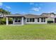 Well maintained grassy backyard featuring a covered back porch and the back of a modern house at 6611 Current Dr, Apollo Beach, FL 33572