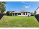 Spacious backyard with lush lawn and dark perimeter fence, complemented by the home's covered porch at 6611 Current Dr, Apollo Beach, FL 33572